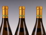three bottles of wine sitting on top of a table next to each other