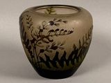 un vase en verre avec un motif sur une surface blanche