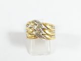 gros plan d'une bague en or et en argent sur une surface blanche