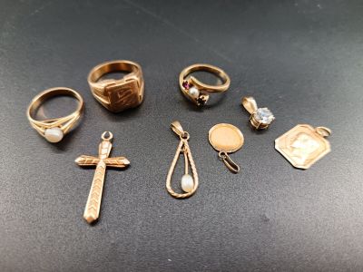 several rings and a cross are sitting on a table