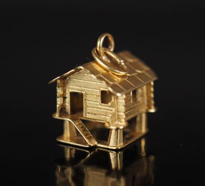 un pendentif en or sur lequel est représentée une petite maison