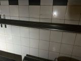 une salle de bains carrelée en noir et blanc, équipée de toilettes et d'un lavabo