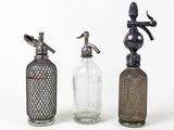trois bouteilles en verre posées les unes à côté des autres sur une table