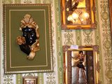 many pictures on the wall of a room with a clock