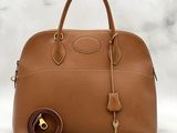 an image of a brown handbag with a key on it