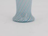 a blue and white striped glass vase sitting on a table