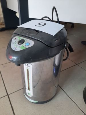 une cafetière argentée et noire posée par terre