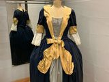 une robe exposée dans un musée, avec un miroir en arrière-plan