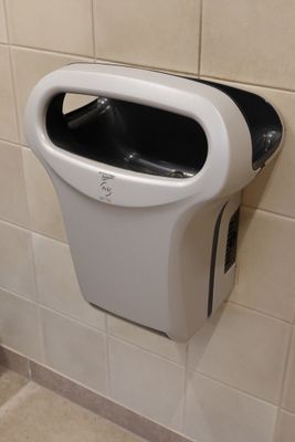un urinoir fixé au mur dans des toilettes publiques