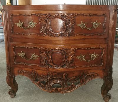 a wooden chest of drawers with ornate carvings on it