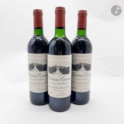 trois bouteilles de vin rouge posées sur une table blanche