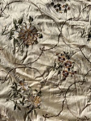 a close up of a bed with a floral design on it