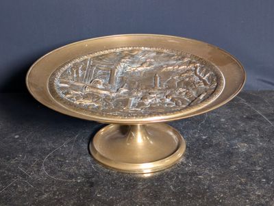 a gold plate with a picture of a city on it