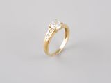 a yellow gold ring with three diamonds on top of it