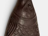 sculpture of a fish on a white surface with a white background