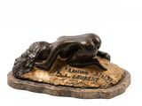 statue en bronze représentant une femme allongée sur un rocher, la tête baissée