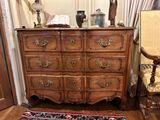 a wooden dresser with many drawers and a rug on the floor