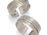 a pair of silver cuff bracelets on a white background