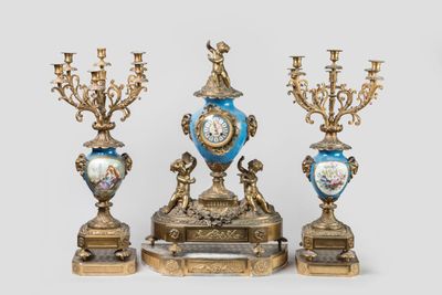 trois types de vases différents et une horloge posés sur une table
