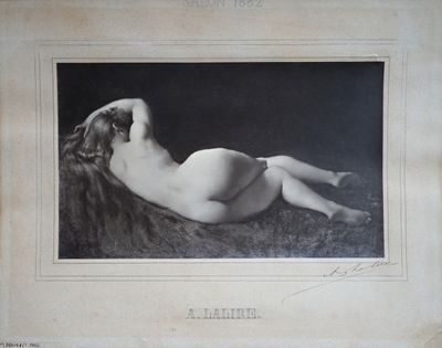 une vieille photo d'une femme nue allongée sur un lit