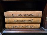 several books are stacked on top of each other on a shelf