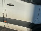 une camionnette blanche garée sur un parking à côté d'un bâtiment
