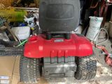 a red and black lawn mower parked in a garage