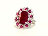 an oval ruby and diamond ring on a white background
