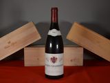 a bottle of wine sitting on a table next to two wooden boxes