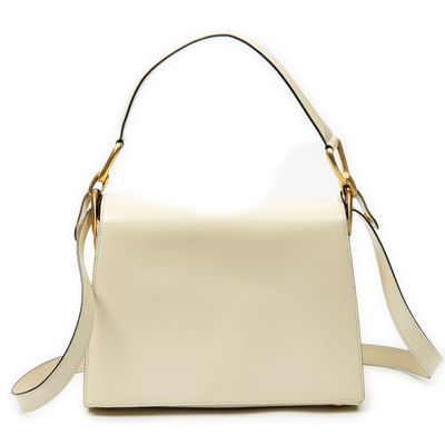a white handbag with a gold handle on a white background