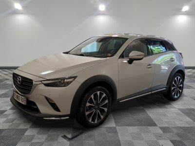 une Mazda CX-3 blanche garée sur un sol à damier