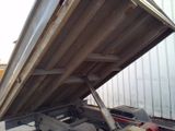 a dump truck that has a large metal container on the back of it