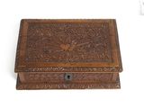 an old wooden box with carvings on it on a white surface