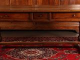 a wooden table with a wooden top on a red rug