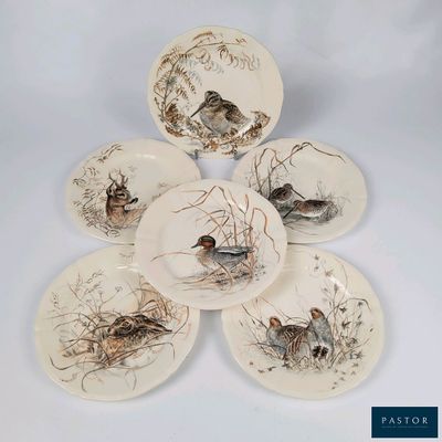 quatre assiettes ornées d'oiseaux, posées sur une surface blanche