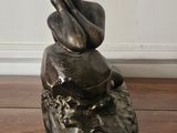 a statue of a woman sitting on top of a wooden box