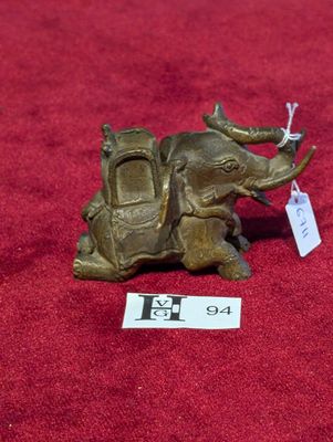 un petit éléphant en bronze avec une étiquette sur le dos