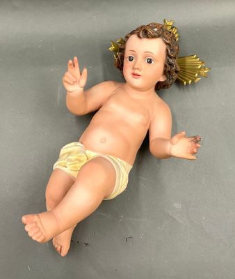 une petite poupée représentant un bébé allongé par terre
