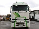 un camion blanc avec des bandes vertes garé sur un parking