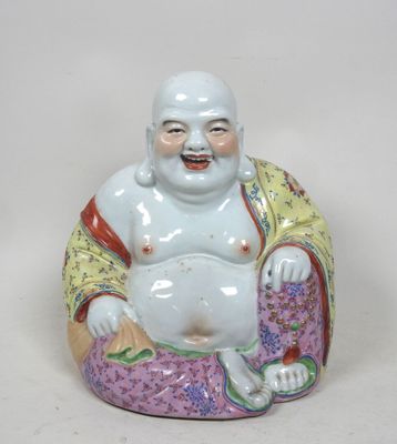 une figurine représentant un Bouddha souriant assis sur un coussin