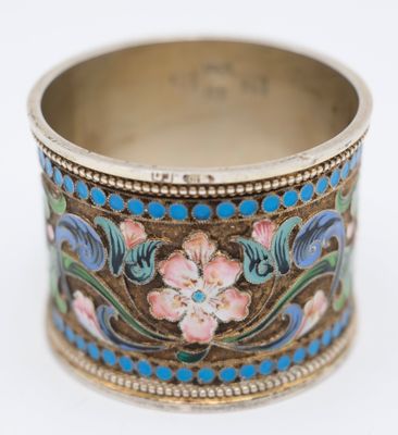 a close up of a ring with flowers on it on a white surface