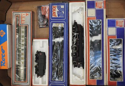 une boîte contenant un assortiment de circuits de trains miniatures dans leur emballage d'origine