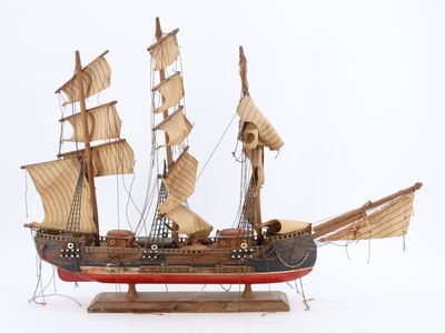 une maquette en bois d'un voilier posée sur un socle