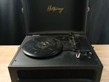 un tourne-disque noir posé sur une table en bois