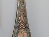 a silver vase that has a yellow tag on it