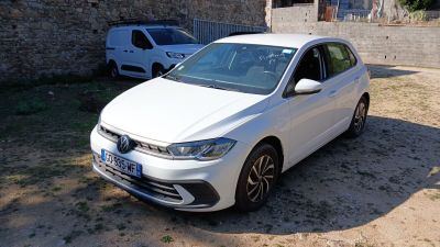 une voiture blanche garée devant un immeuble en briques