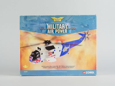 hélicoptère militaire miniature dans sa boîte, posé sur une surface blanche