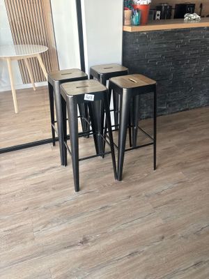 trois tabourets placés devant un comptoir dans une pièce
