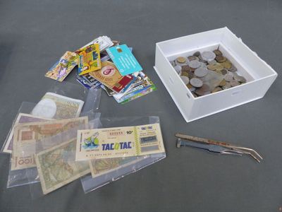 une boîte remplie d'argent et une paire de ciseaux posés sur une table