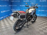 a picture of a white and red motorcycle parked in front of a blue backdrop
